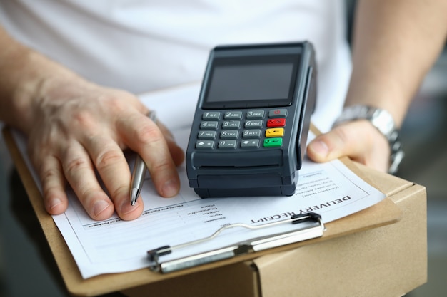 Man holds parcel delivery document and terminal