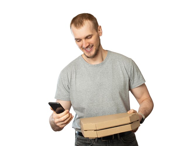 A man holds a phone and a pizza in his hands on a black backgroundPizza delivery