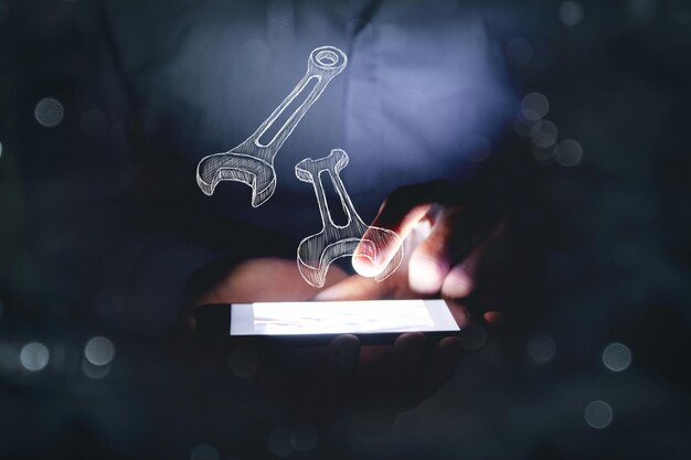 Man holds the phone over which wrenches. concept technical support