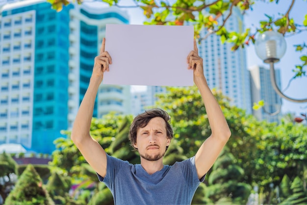 Man holds a poster free for inscriptions in the city