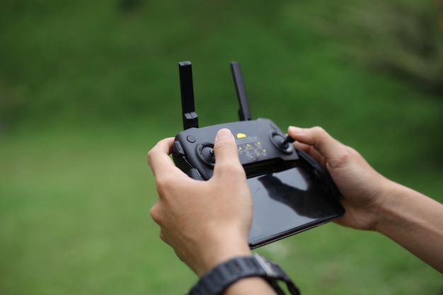 A man holds a remote controller with his hands and controls the drone