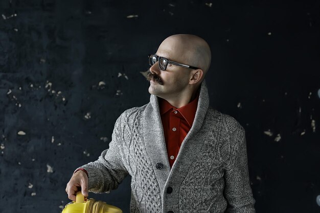 man holds a suitcase, tourist concept, trip mustachioed guy with glasses, eccentric type