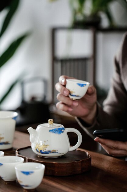 Photo a man holds a tea cup and saucer with a blue and white design on it.