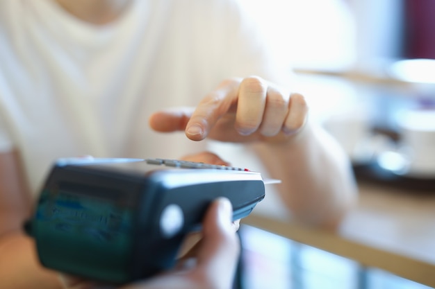 Man holds terminal with a plastic card in his hand. Safe payments concept