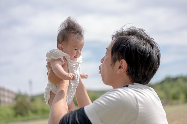 A man holds up a baby in the air