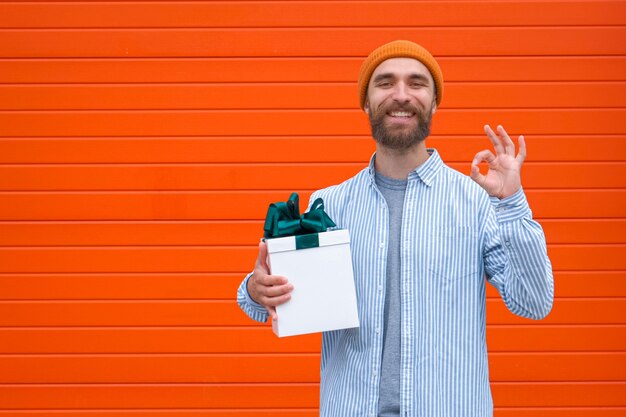 Man holds white box with green bow