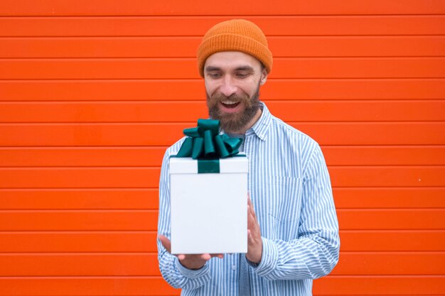 Photo man holds white box with green bow