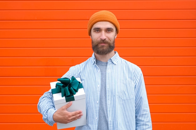 Man holds white box with green bow