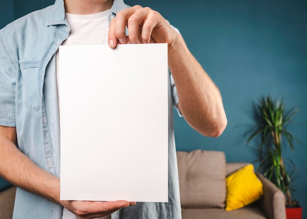 Man holds a white piece of paper