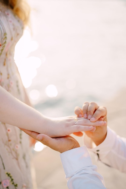 Man holds a woman hand with a engagement ring closeup