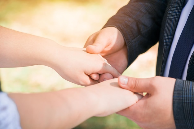 A man holds women's hands on the street in the sunlight Closeup