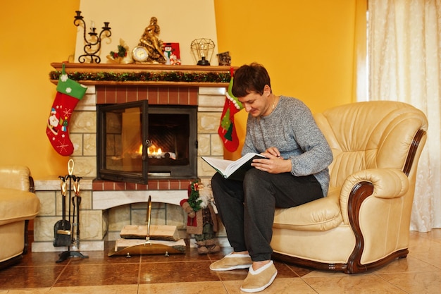 Man at home by a fireplace in warm living room on winter day