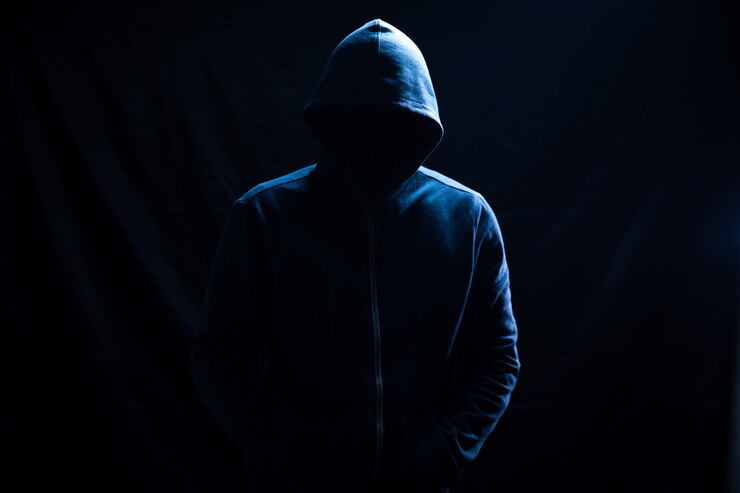 Photo a man in a hood stands on black