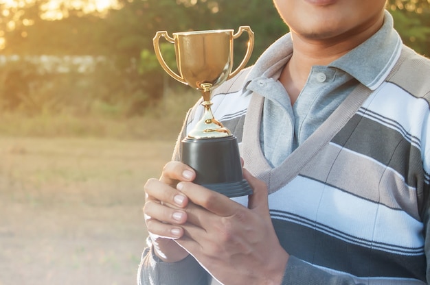 Man houdt gouden trofee beker