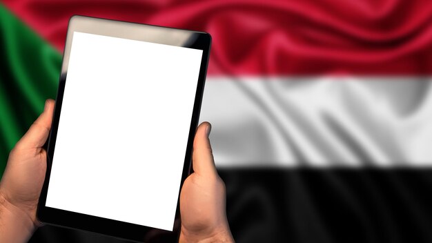 Man houdt tablet telefoon pc Vlag van Soedan land op de achtergrond