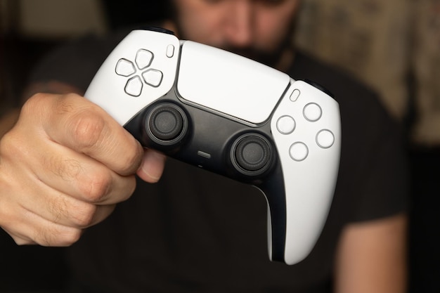 Man houdt witte gamecontroller vast