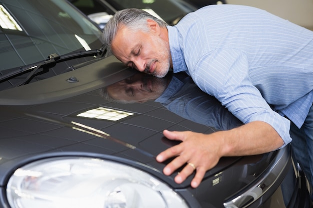 Photo man hugging on a car