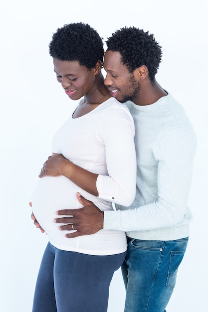 Man hugging his pregnant wife while standing 