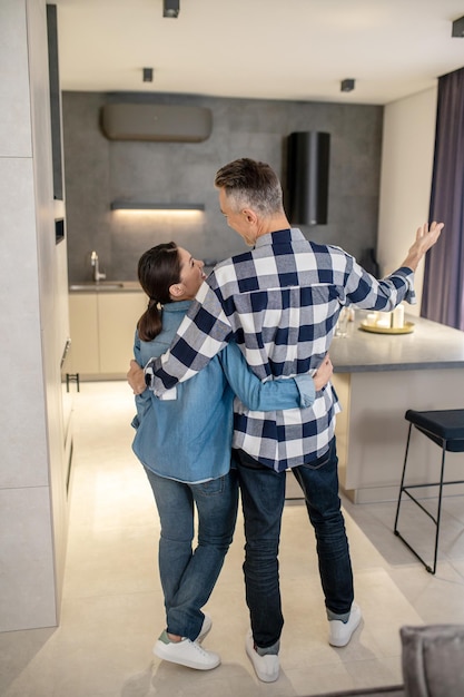 Man hugging woman standing with back to camera