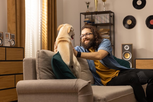 男は仕事から戻った後に彼の犬を抱きしめます犬の飼い主は仕事から戻った後に彼のペットに挨拶します