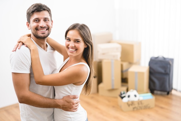 The man hugs a woman on the background of boxes