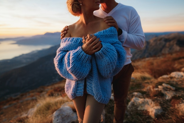 Man hugs a woman in a blue sweater by the shoulders