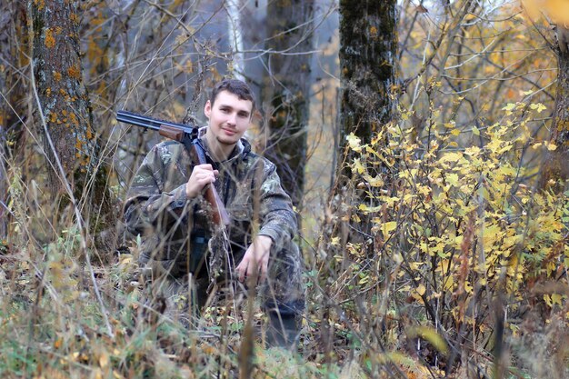 Man hunter outdoor in autumn forest hunting alone