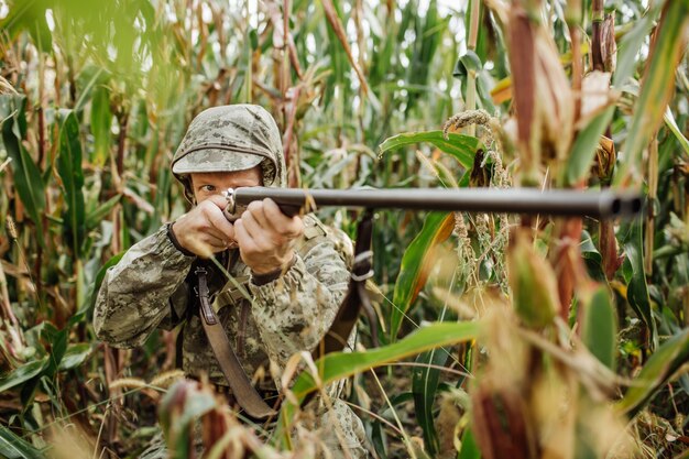 Man hunter with shotgun in forest