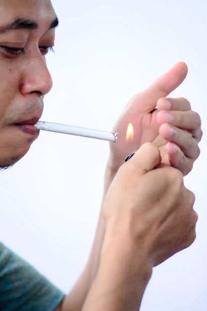 Photo man igniting cigarette against white background