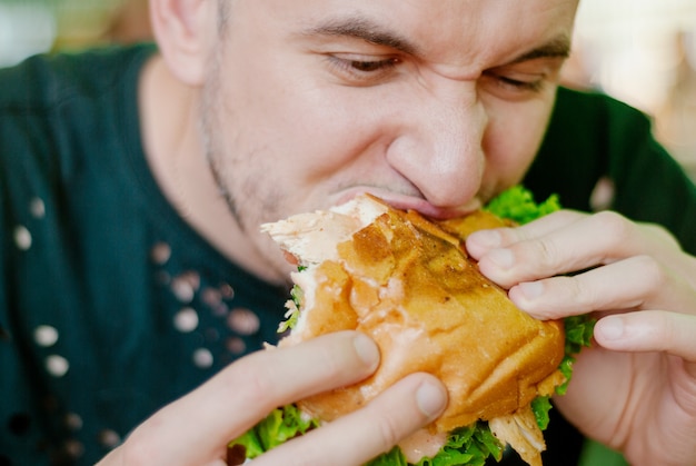 写真 ハンバーガーを食べるレストランの男