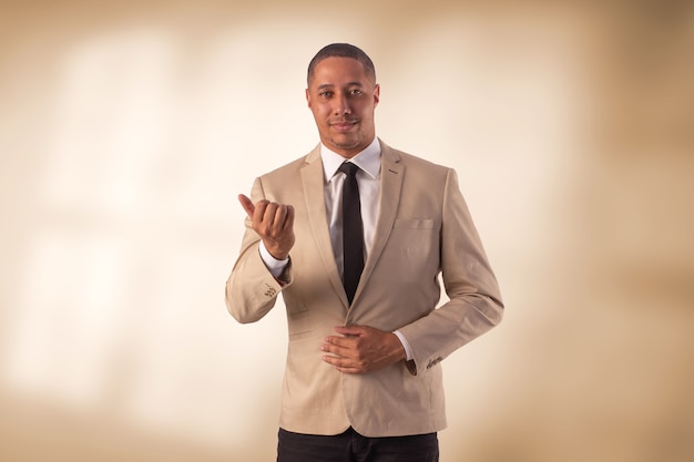 Man in beige pak in studio foto op een achtergrond met verlichting.