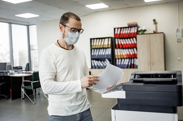 Man in beschermend masker kopieert documenten