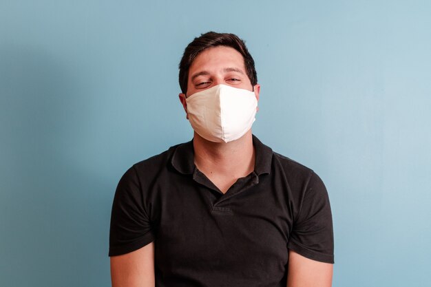 Man in beschermend medisch masker met geïsoleerd in blauw