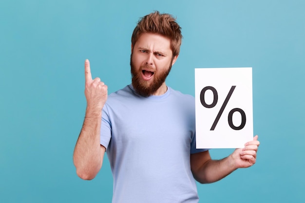 Man in blauw t-shirt met papier met procentteken naar boven gericht met de vinger die naar de camera kijkt