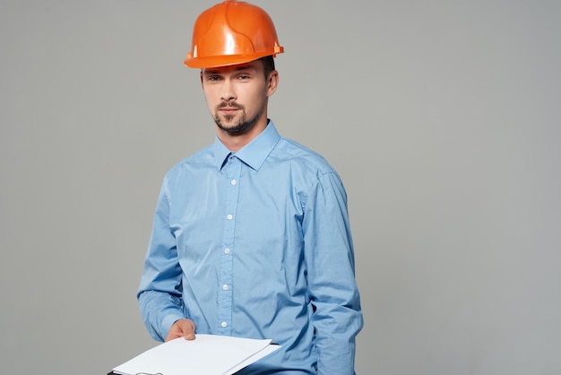 Man in bouwuniform blauwdrukken bouwer lichte achtergrond foto van hoge kwaliteit