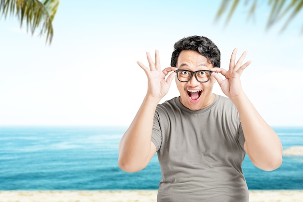 Man in bril met een opgewonden uitdrukking op het strand