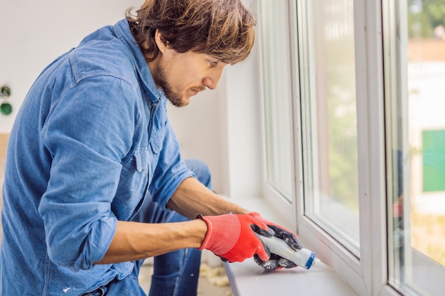 Man in een blauw shirt doet raaminstallatie.