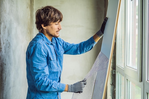 Man in een blauw shirt doet raaminstallatie.