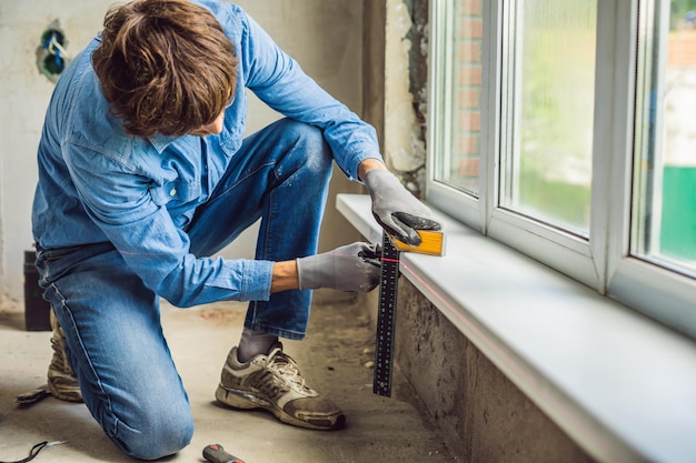 Man in een blauw shirt doet raaminstallatie.