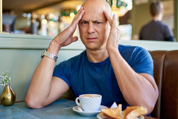 Man in een café bij het ontbijt