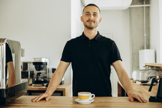 Man in een coffeeshop die een kopje cappuccino serveert