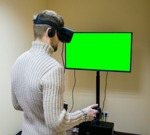 Man in een helm virtual reality speelt een spel