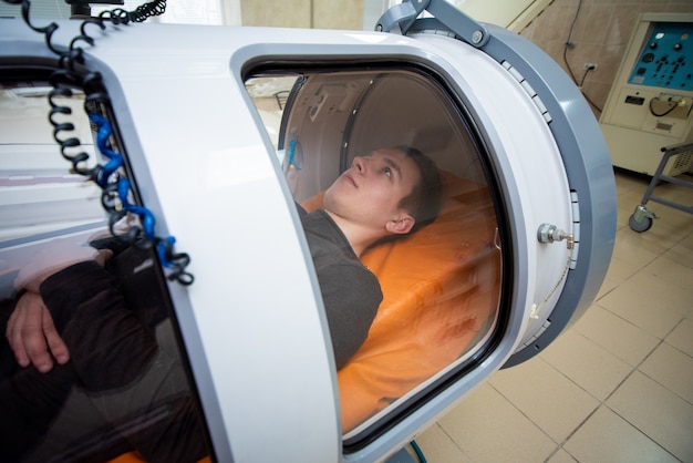 Man in een hyperbare kamer, zuurstofbehandeling, medische kamer