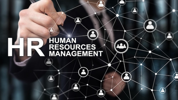 Man in een jas op een donkere achtergrond schrijft tekst op een virtueel scherm Human resource management HR