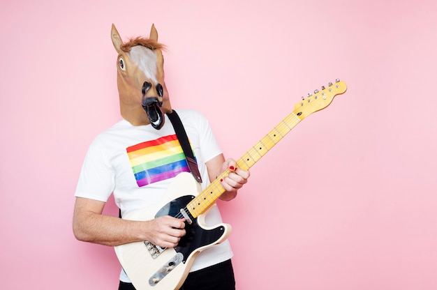 Foto man in een paardenmasker elektrische gitaar spelen.