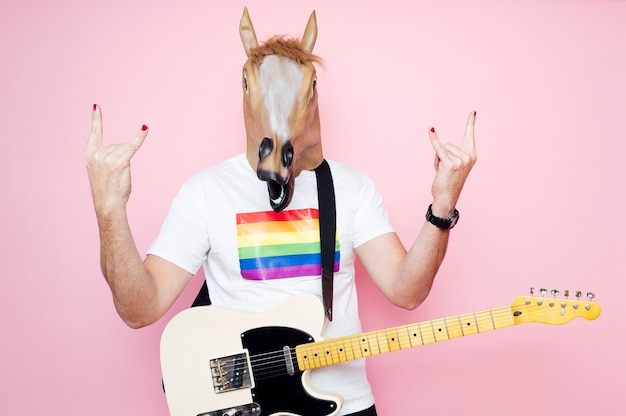 man in een paardenmasker elektrische gitaar spelen.