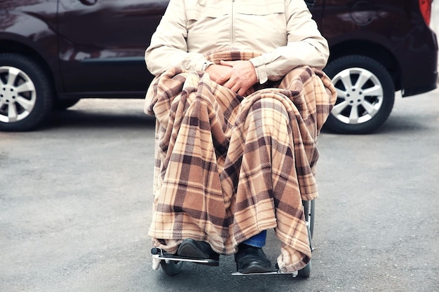 Man in een rolstoel voor zijn auto