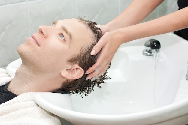 Man in een salon krijgt zijn haar gewassen