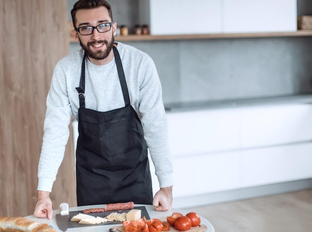 Man in een schort die salami snijdt voor broodjes