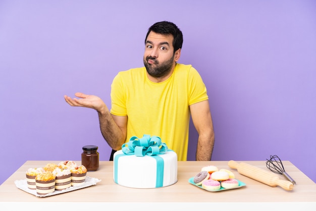 Man in een tafel met een grote taart ongelukkig voor iets niet te begrijpen